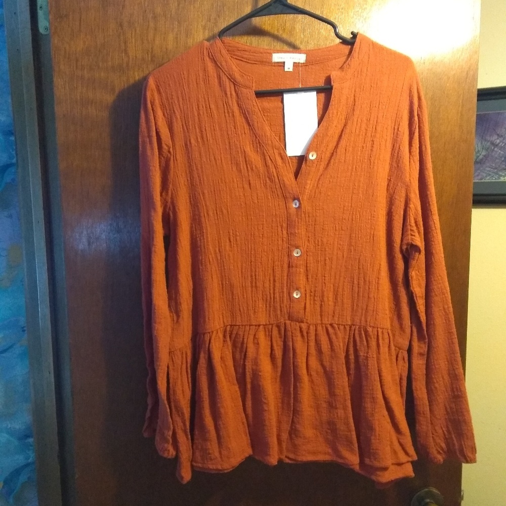 Rust colored button shirt with ruffle.